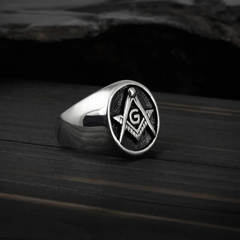 Angled silver-tone Masonic ring on dark surface
