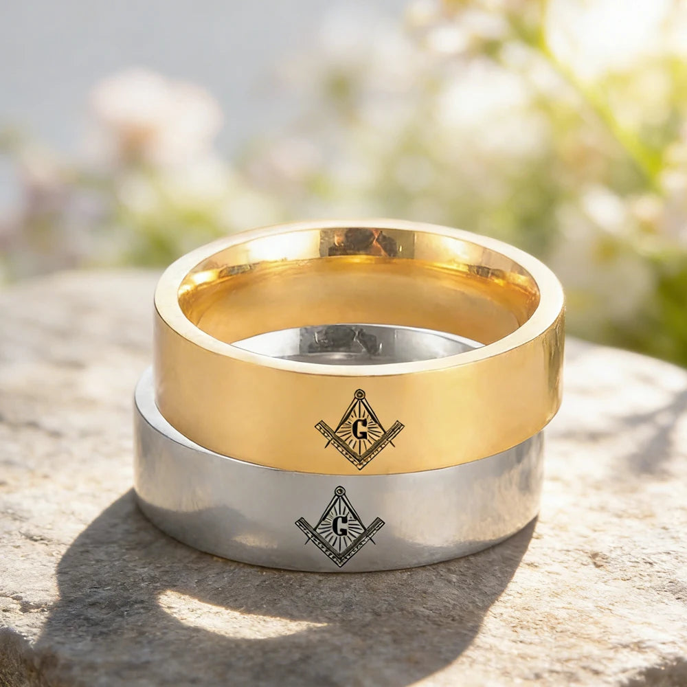 Gold-tone and silver-tone engraved Masonic bands stacked outdoors