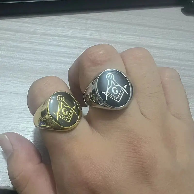 Two black-face Masonic rings shown on a hand