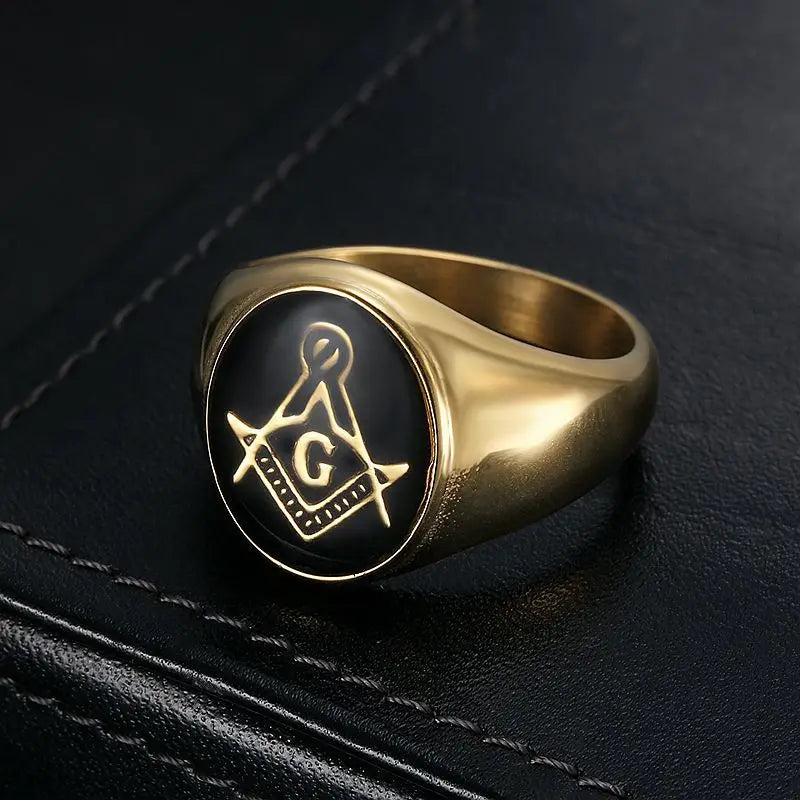 Gold-tone black medallion Masonic ring angled on dark surface