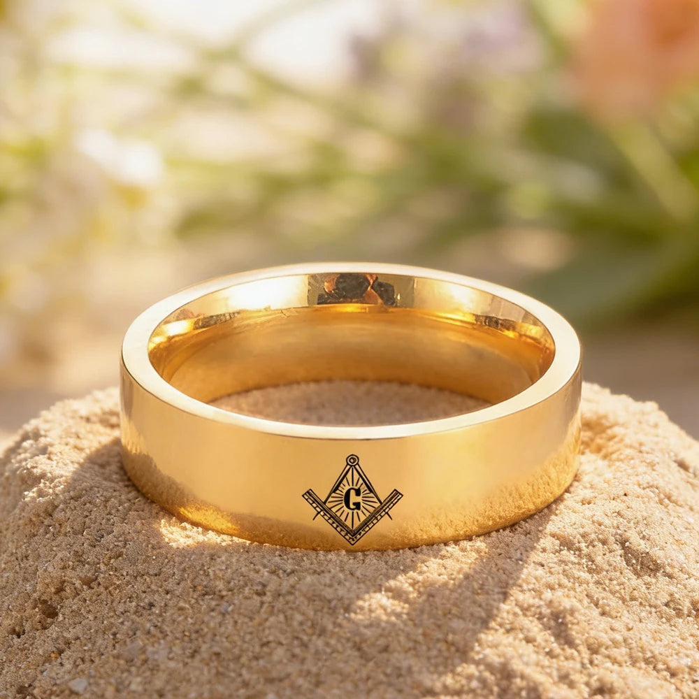 Gold-tone engraved Masonic band displayed on stone