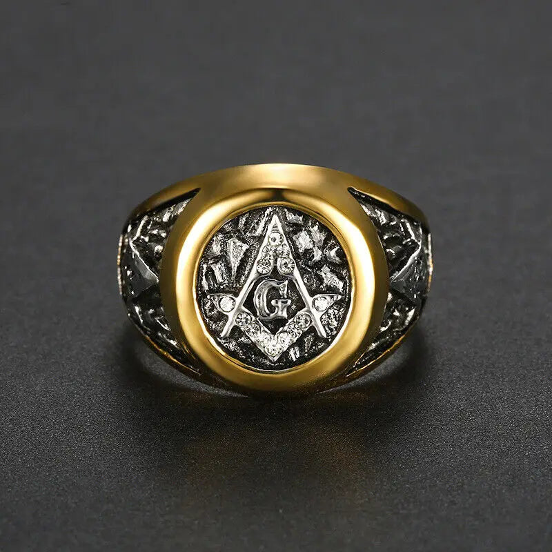 Front of gold-rimmed Masonic ring on dark surface