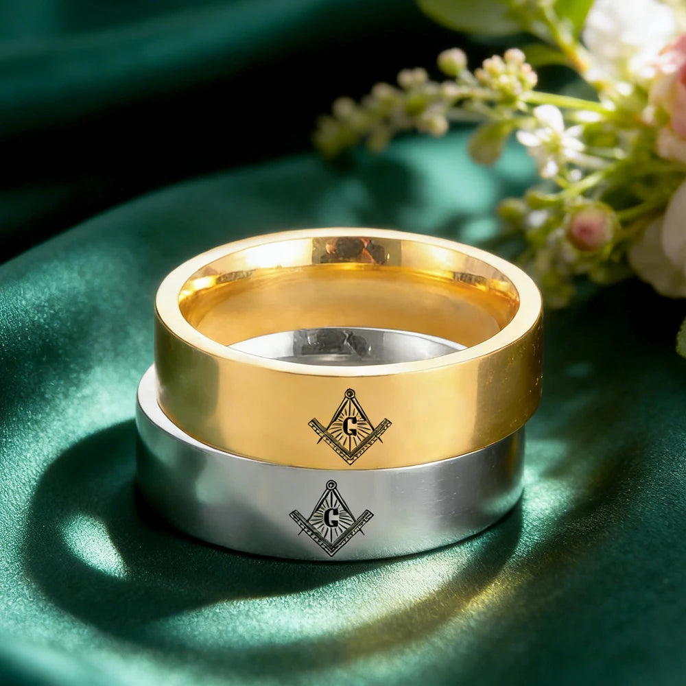 Two engraved Masonic bands displayed on green fabric