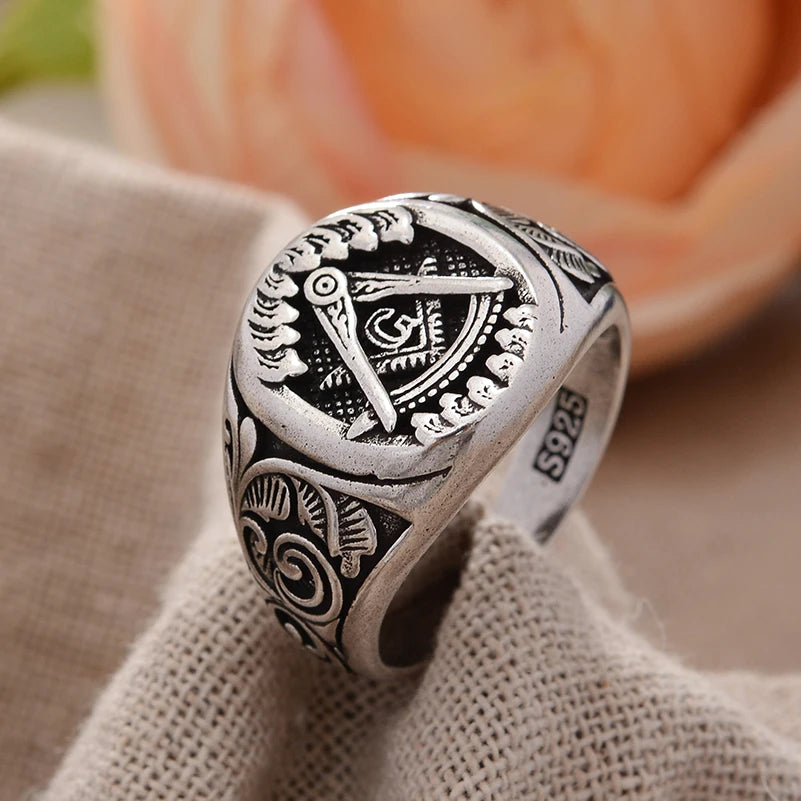 Silver-tone oval Masonic scrollwork ring on fabric
